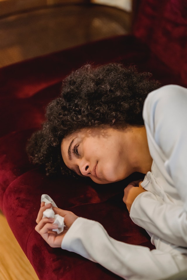 Sad woman lying on a red pillow